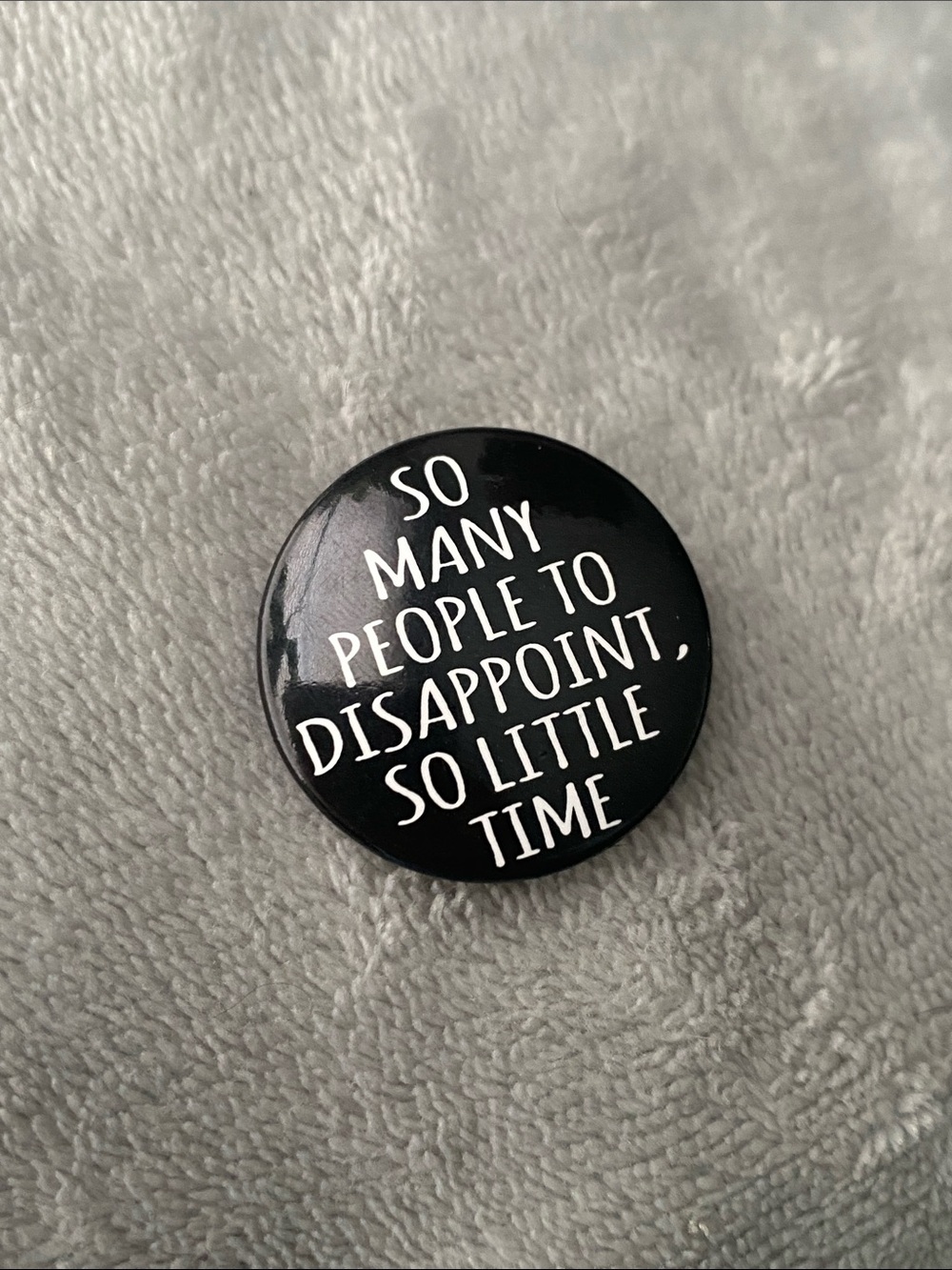 Button pin that says “So many people to disappoint, so little time”